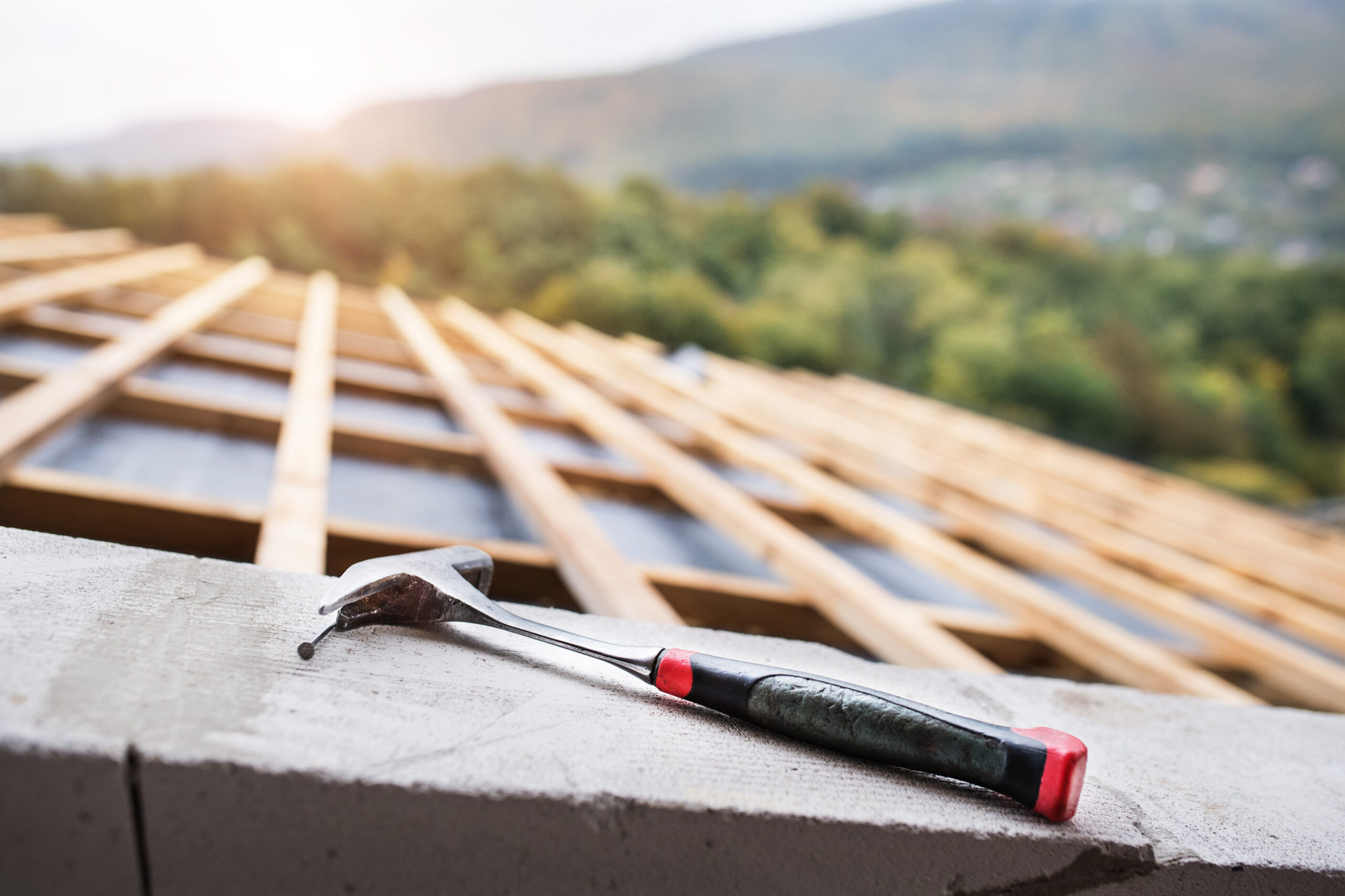 Residential roof replacement Houston with hammer on wooden roof frame under construction